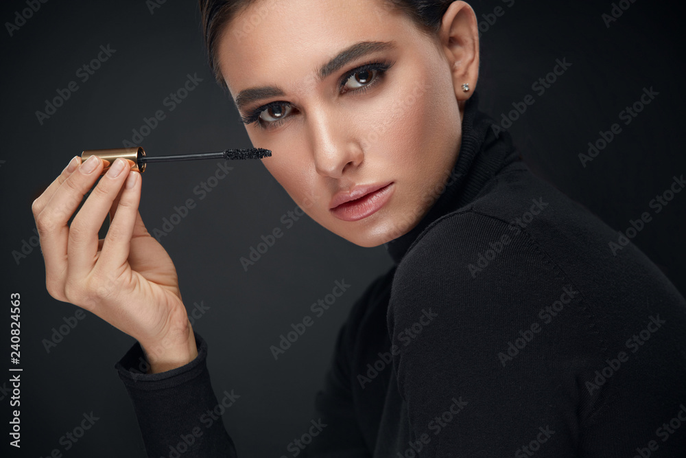 Obraz premium Makeup Cosmetics. Woman With Beauty Face Applying Black Mascara