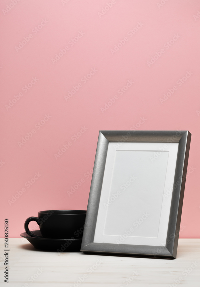 silver frame with mug on white desk near pink wall silver frame with mug on white desk near pink wall