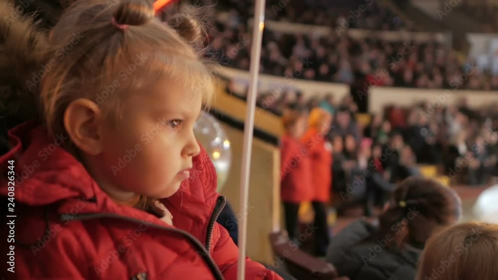 Little girl applauds looking at a circus performance Little girl applauds looking at a circus performance