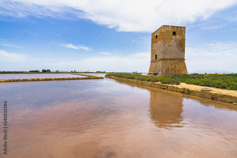 Salt evaporation pond and Nubia tower at salt flats near Trapani, Sicily, Italy