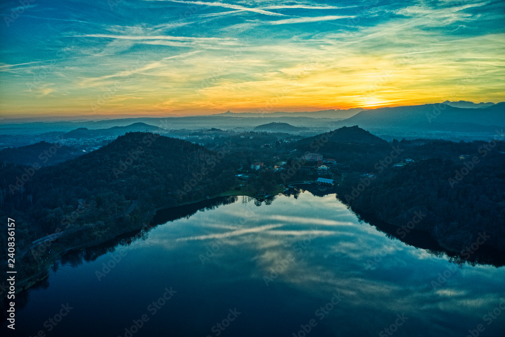 Aerial sunset over the lake in Italy during golden hour with mountains reflections