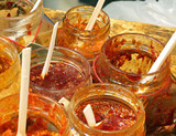 jars with spicy tomato sauce and chilli pepper and spoons to tas