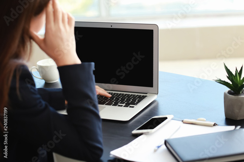 Stressed businesswoman with non-working laptop sitting at workplace in office