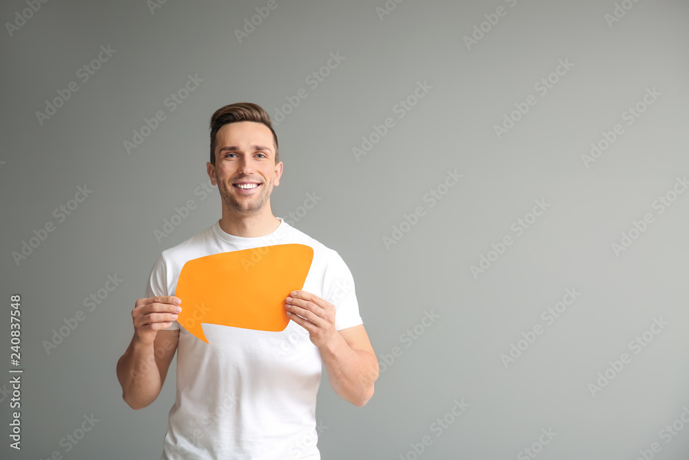 Young man with speech bubble on grey background Young man with speech bubble on grey background