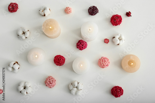 Beautiful composition with candles and cotton flowers on white background