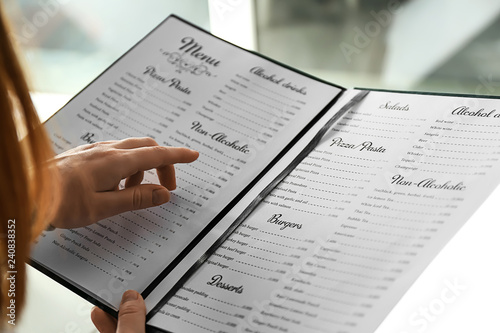 Stampa su tela Woman reading menu in cafe, closeup