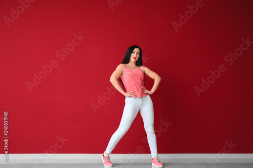 Young woman dancing near color wall