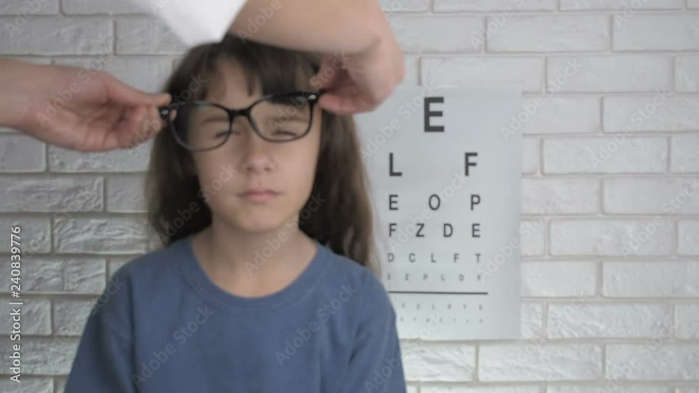 Child sees blurry. An ophthalmologist puts glasses on a little girl. Child sees blurry. An ophthalmologist puts glasses on a little girl.
