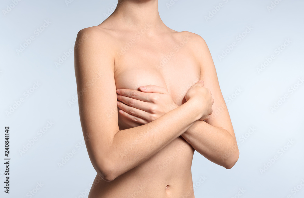 Young woman with beautiful breast on light background Young woman with beautiful breast on light background
