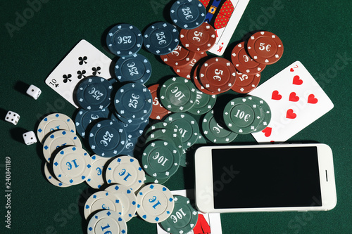 Chips, cards and mobile phone on table in casino