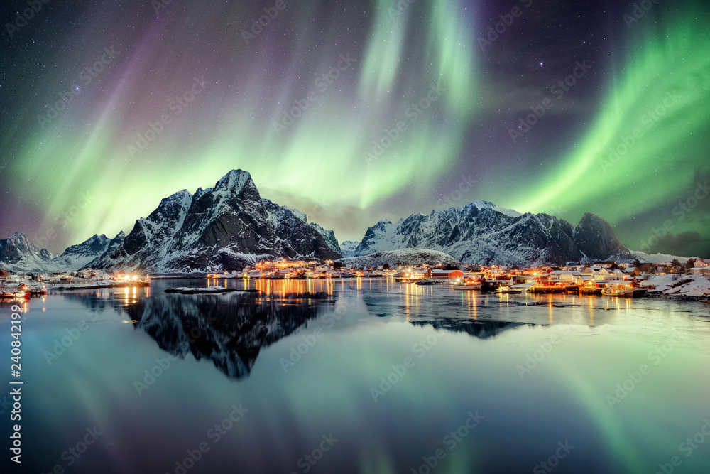 Aurora borealis dancing on mountain in fishing village - obrazy, fototapety, plakaty 