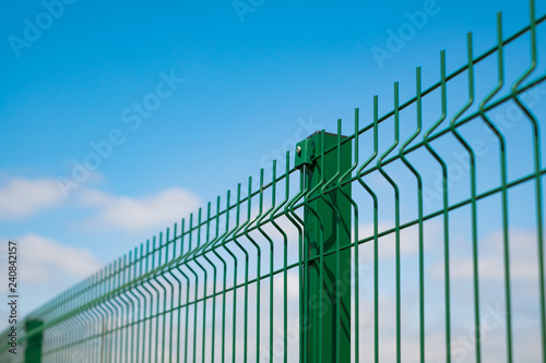 Steel grating fence made with wire on blue sky background. Sectional fencing installation