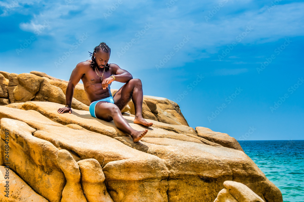 Muscular African American Man Sitting on a Rock