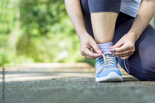 woman runner typing shoelace wearing shoes getting ready for running © doucefleur