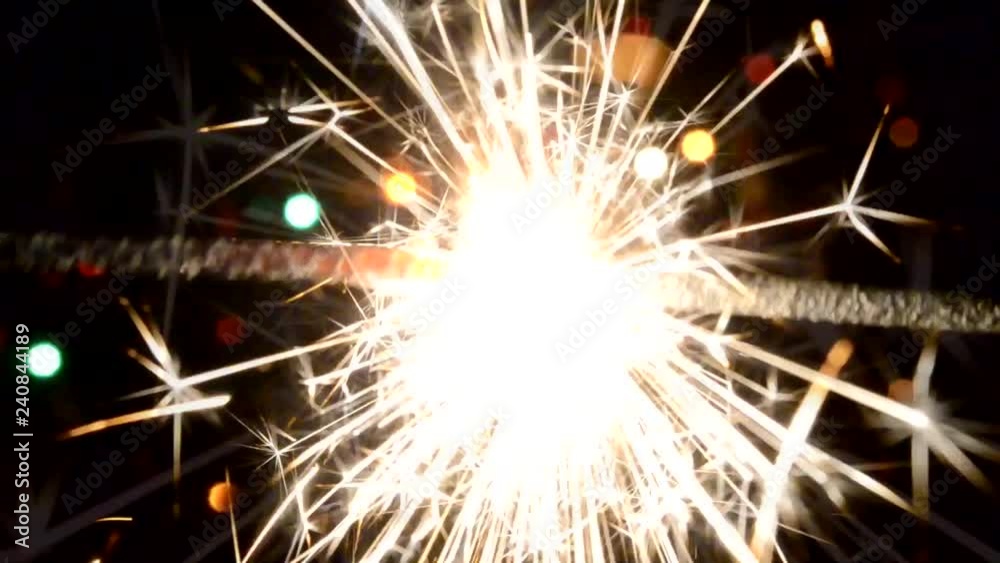 sparkler on Christmas tree lights background sparkler on Christmas tree lights background