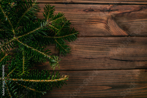 Background texture of a fir tree branches on the wooden table. Christmas card template.