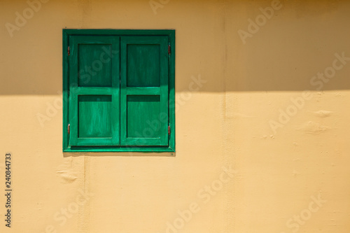 Green window on a yellow wall