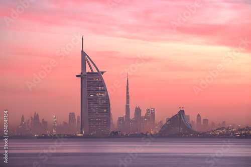 Photo Stunning view of Dubai skyline from Jumeirah beach to Downtown lighted with warm pastel sunrise colors