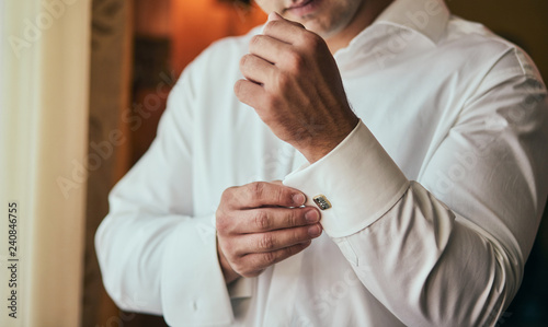 businessman dresses white shirt, male hands closeup,groom getting ready in the morning before wedding ceremony