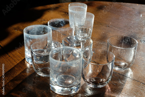 Ensemble de verres vides sur un table, traces et salissure légères sur les verres
