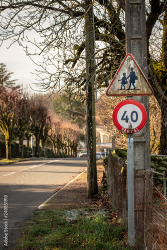 Panneaux signalistaion ancients, vitesse et tranversée enfants sur bord de rue.