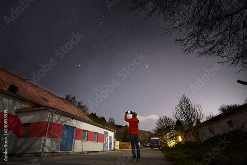 Sky full of stars and a boy photographing stars with his mobile phone