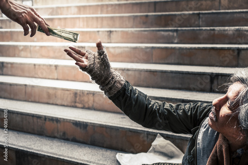 фотографія mercy hand give money to hand of poor homeless beggar selective focused