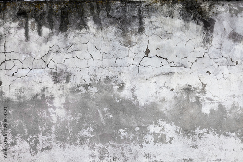 Cracked concrete wall covered with gray cement surface. Old grunge textures b...