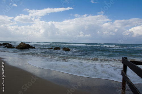 Waves crashing on shoreline with moody dramatic sky © Pavel