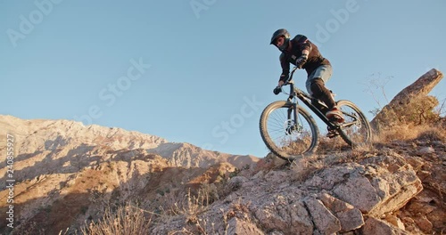 Cycler pedaling down the track in mountains during sunset, following the path, and getting away from it all 4k