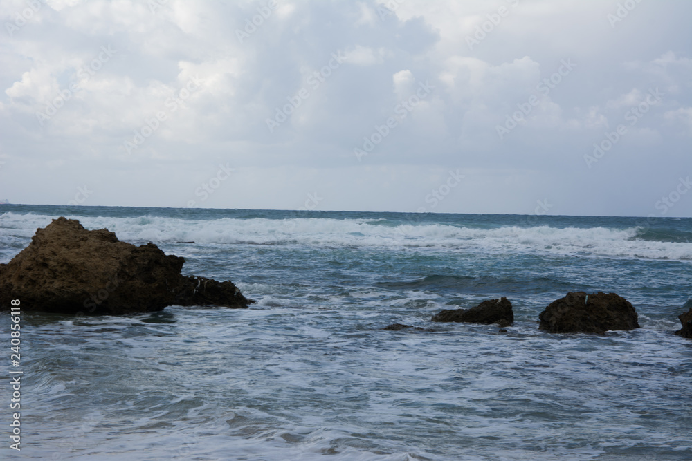 Waves crashing on shoreline with moody dramatic sky Waves crashing on shoreline with moody dramatic sky