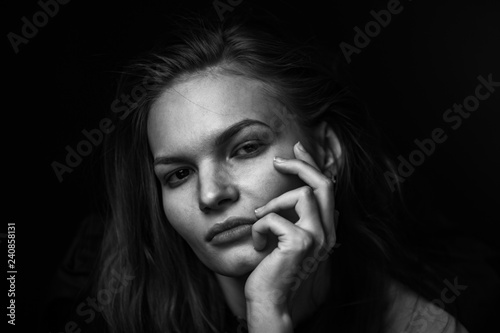 Dramatic black and white portrait of a beautiful girl on a dark background