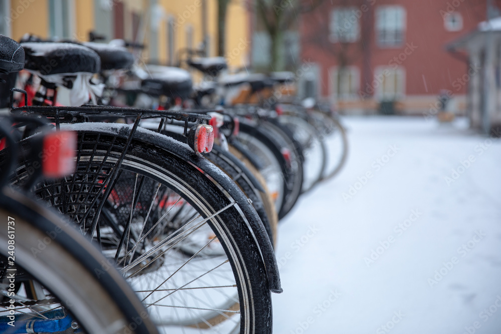 winter bikes parked in a row outside apartment buildings