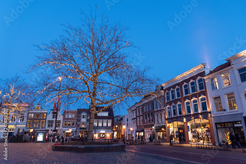 Cuadro en lienzo Winter tree on the market square of Gouda, The Netherlands, with medieval houses an a lot of lights and a blue sky in the twilight