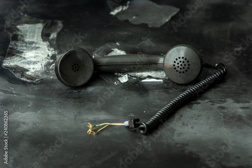 Obraz na plátně An old telephone earphone from the 50s on a black table in a dark room