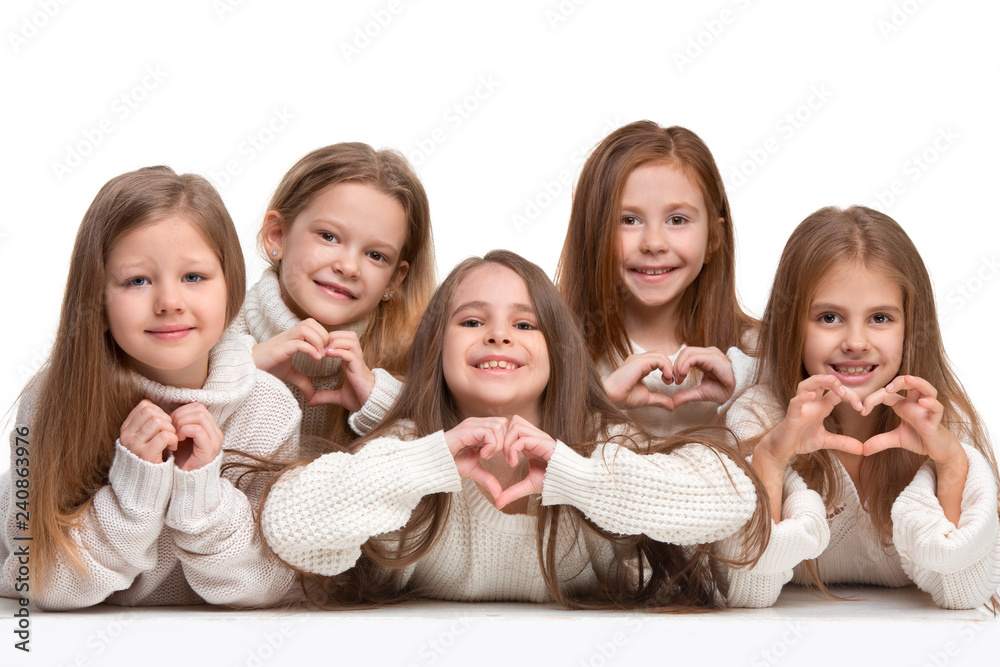 portrait of cute little kids girls in stylish knitted sweater looking at camera and smiling against white studio wall. Kids fashion concept portrait of cute little kids girls in stylish knitted sweater looking at camera and smiling against white studio wall. Kids fashion concept