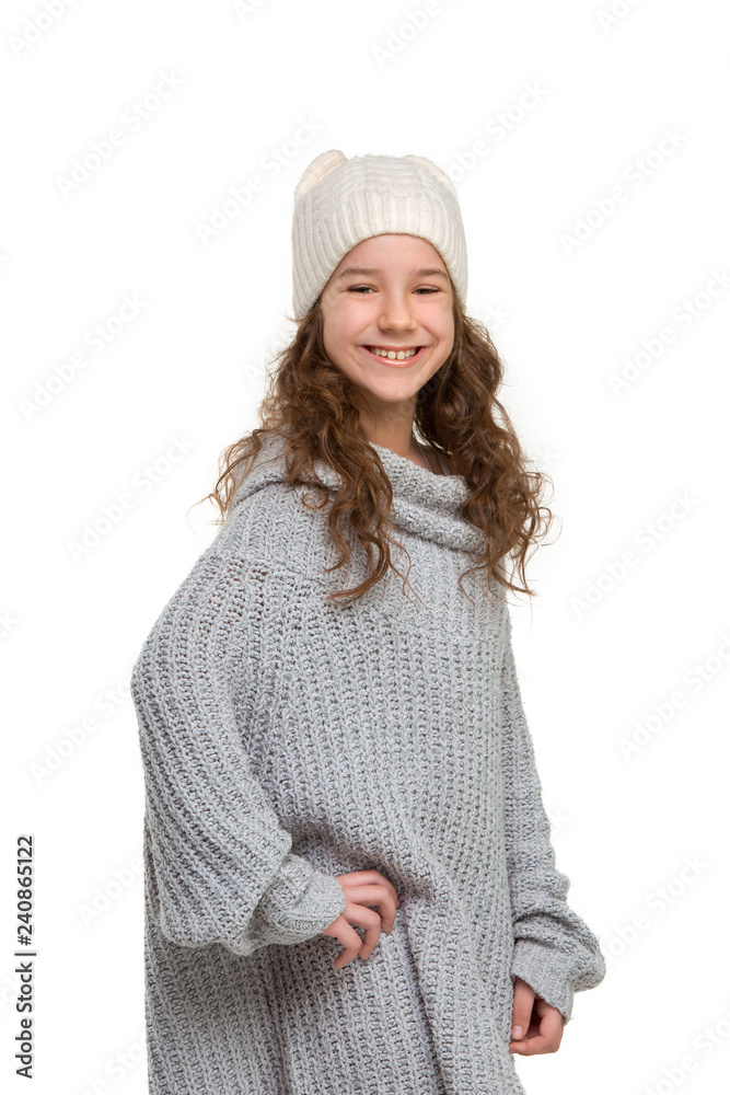 portrait of cute little kid girl in stylish knitted sweater looking at camera and smiling, standing against white studio wall. Kids fashion concept portrait of cute little kid girl in stylish knitted sweater looking at camera and smiling, standing against white studio wall. Kids fashion concept