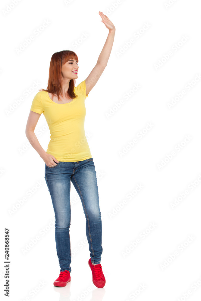 Smiling Casual Young Woman Is Standing Waving Hand And Looking Away Smiling Casual Young Woman Is Standing Waving Hand And Looking Away