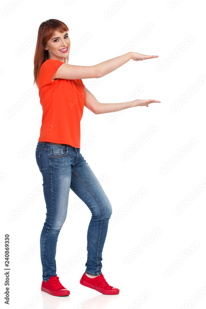 Smiling Young Woman Is Holding Something, Looking At Camera Smiling Young Woman Is Holding Something, Looking At Camera