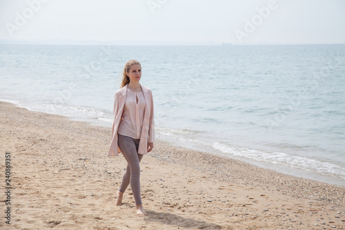 woman walking on sandy beach, one sea coast © dmitriisimakov