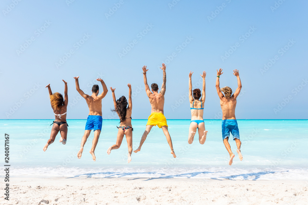 Group of friends at the beach, jumping for joy