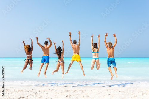 Group of friends at the beach, jumping for joy
