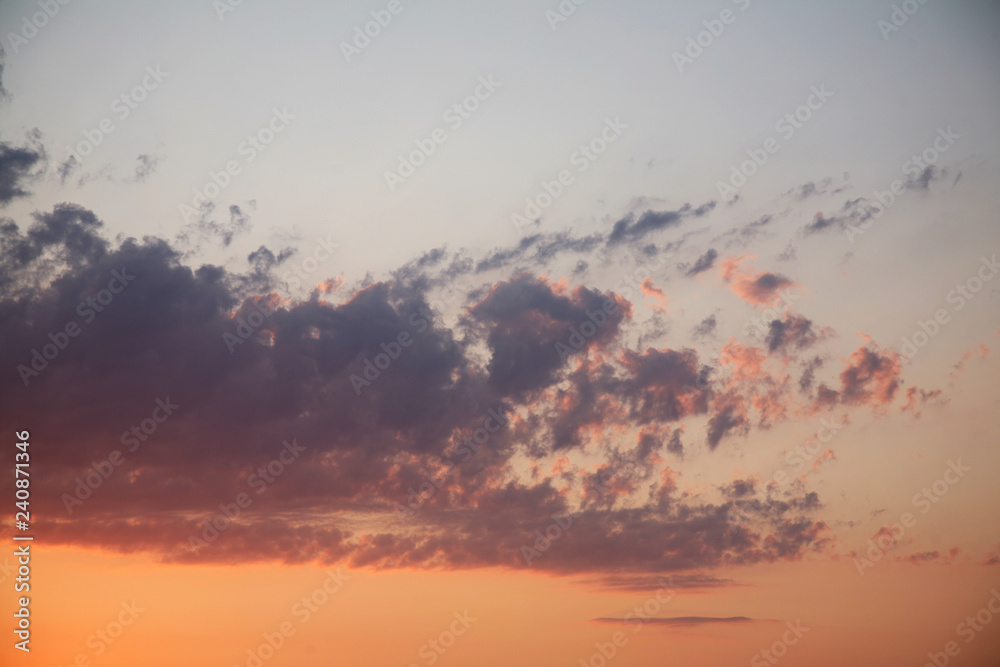 Sky background beautiful image. Abstract background is decorated with different types of clouds. Sunset in the evening sky. The sun  rays illuminate the clouds.