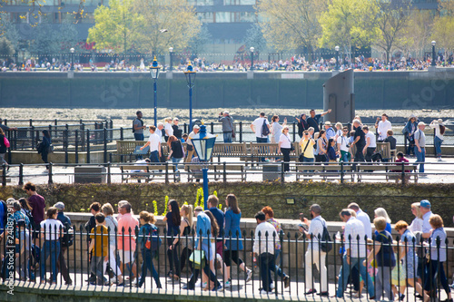 London, UK. Lots of people crossing the footbridge near the Tower of London. Rush hours concept