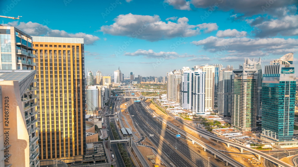 Fototapeta premium Aerial view of Dubai marina skyscrapers and Jumeirah lakes towers timelapse with traffic on sheikh zayed road.
