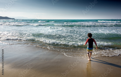 Fotografia Boy walking into sea Crete Greece Europe