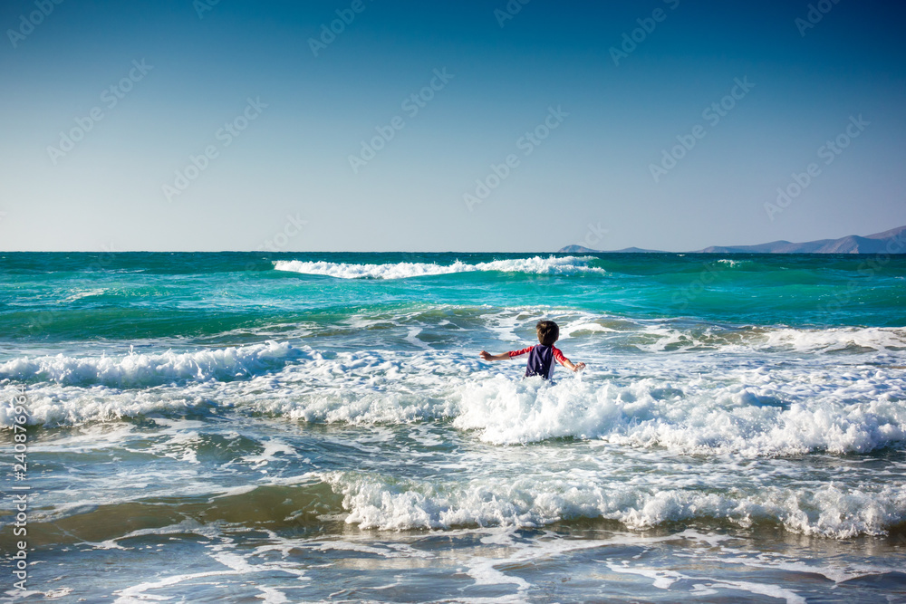 Boy amidst sea waves Crete Greece Europe