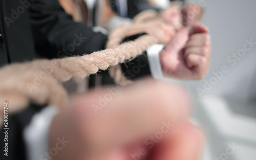 Hands of businessmen, twisted by a rope