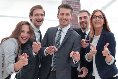 A group of business people standing and pointing at you