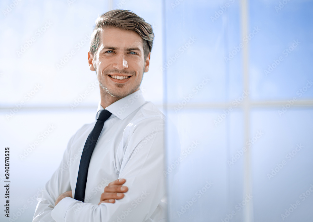 Fototapeta premium smiling businessman standing near the office window